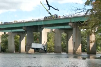 Crane gently lifts box truck out of river after seven vehicle crash sends it off bridge
