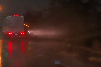 Semi truck sliding on rainy road misses smashing a four wheeler by just a hair: VIDEO