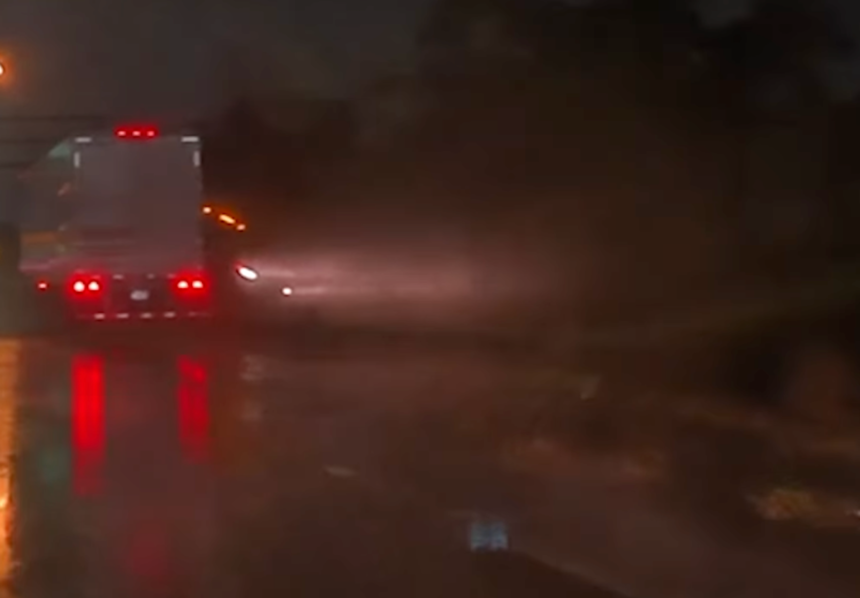 Semi truck sliding on rainy road misses smashing a four wheeler by just a hair: VIDEO